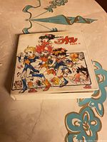 Front view of white case showing anime artwork and series title