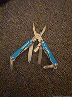 Multitool open displaying pliers, blade, file and screwdriver heads