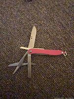 Leatherman Style multitool open showing knife, scissors, file