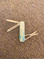 Knife with blade, nail file and scissors extended