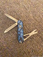 Knife open showing blade, nail file and scissors