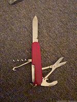 Knife open showing blade, scissors, combo tool, corkscrew, hook