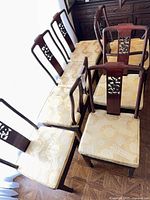 Top view showing all seven chairs aligned, highlighting wood color and cushion fabric