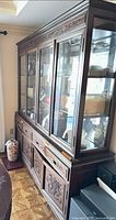 Full view of carved wood china cabinet with glass hutch and buffet base