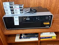 Front view of Epson Stylus Photo R3000 with stacked ink cartridge boxes, foil cartridges and power cable on top