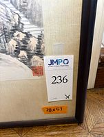 Front lower corner showing mat, frame edge, artist seal and size tag