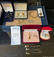 Overview of entire lot in tray showing multiple cufflink sets, tie bars and cuff bracelet