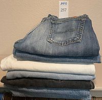 Stack of four folded jeans in assorted colours