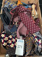 Box containing assorted neckties, belts, and belt hanger