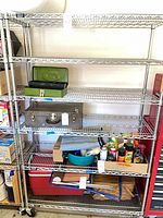 Full view of five-shelf chrome wire unit loaded with miscellaneous items (contents excluded)
