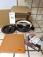 Rice cooker components, lid, pot, heat diffuser tile, instruction booklet