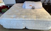 California king mattress on split box springs with metal frame and mattress cover visible