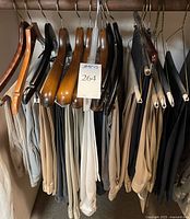 Slacks hanging on wooden and plastic hangers