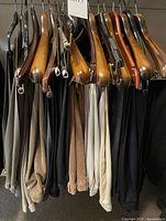 Full view of hanging slacks on wooden hangers