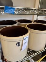 Five matching crocks on shelving