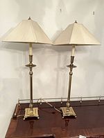 Pair of brass candlestick table lamps on table