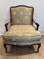 Front view of bergere armchair showing floral upholstery and wood frame