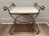 Front angled view showing wrought iron frame, scroll arms, upholstered seat