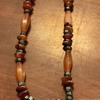 Section of necklace showing carnelian discs, elongated bead and silver spacers