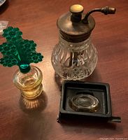 Overall view of Enots atomizer, green-stopper bottle and miniature bottle in black frame