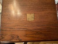 Top of oak box showing brass shield inlay and repaired crack