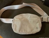 Full view of off-white Lululemon belt bag with strap displayed