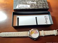 Watch in opened Disney box showing strap and dial