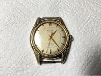 Front view of Fludo wristwatch showing dial, case, lugs and scratched acrylic crystal