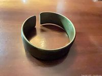 Top view of wide brass cuff showing open end and patina