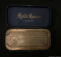 Open case showing blue satin lid branding and metal strop/hone carriage