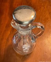 Full view from above of jug showing sterling top and clear cut glass body