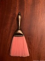 Full view of crumb brush showing sterling handle and pink bristles