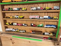 Full view of four shelves filled with assorted die-cast vehicles