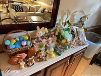 Entire countertop view of Easter decorations showing baskets, figurines, eggs, wood stakes