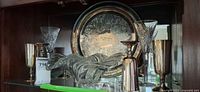 Cabinet view showing silverplate tray, crystal glasses, silver goblets, art glass bowl