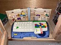 LeapFrog LeapDesk in front of wooden dollhouse halves with furniture and dolls