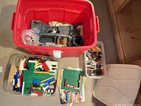 Overall view of red tote and two clear bins with LEGO pieces