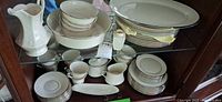 Cabinet view showing dinner plates, platter, salad bowl, soup bowls, cups, saucers, sugar, creamer, relish tray