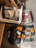 Overall view: two orange Bostitch staplers, black Bostitch bag, grey Porter Cable stapler in white drawer, clear bin of staples