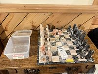 Overall view of stone chess board with pieces and plastic tub