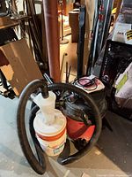 Overall view of Craftsman vacuum, cyclone separator on bucket, hoses, wands in basement setting