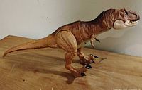 Left side full view of Tyrannosaurus Rex figure on wooden surface
