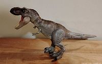 Left side profile of the T. rex figure standing upright