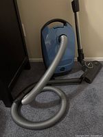 Full view of Miele Classic C1 canister vacuum with hose, wand and floor head