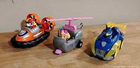 Three Paw Patrol vehicles with figures lined up