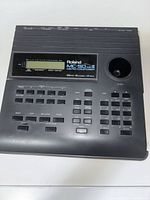 Front view of Roland MC-50 MkII showing display, buttons, floppy drive