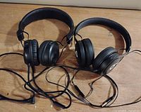Both pairs of black on-ear headphones with cables displayed