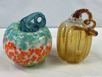 Both pumpkins side by side showing size, colors, and stems