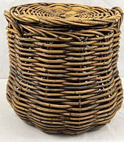 Full view of cylindrical rattan basket showing weave and shape