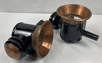 Two black metal carriage lanterns with copper reflectors shown together